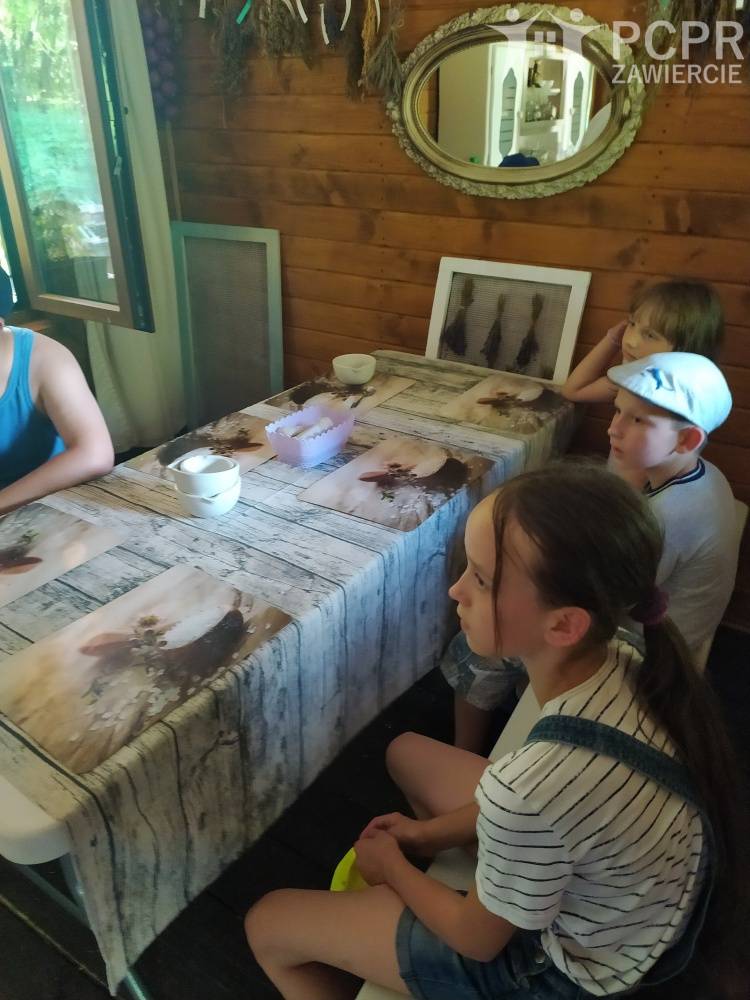 Zdjęcie: Grupa dzieci siedzi przy stole i słucha